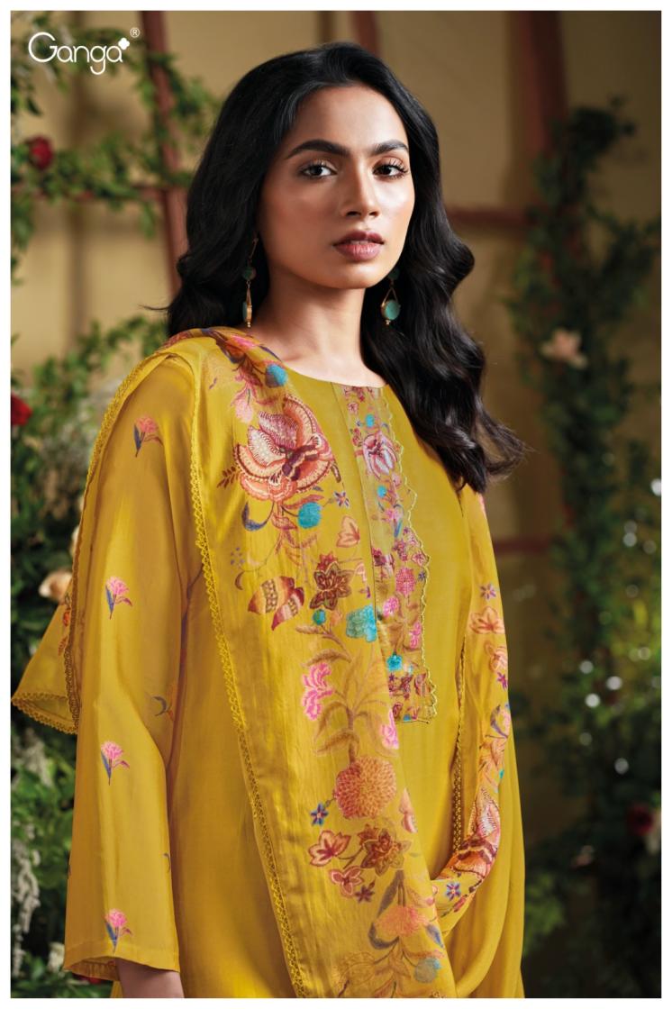 Woman wearing a yellow embroidered dress with floral patterns against a blurred natural background