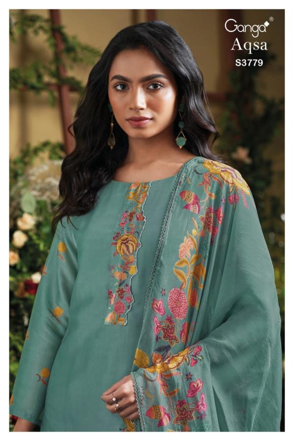 Woman wearing a teal embroidered outfit with floral patterns, brand 'Ganga' visible.