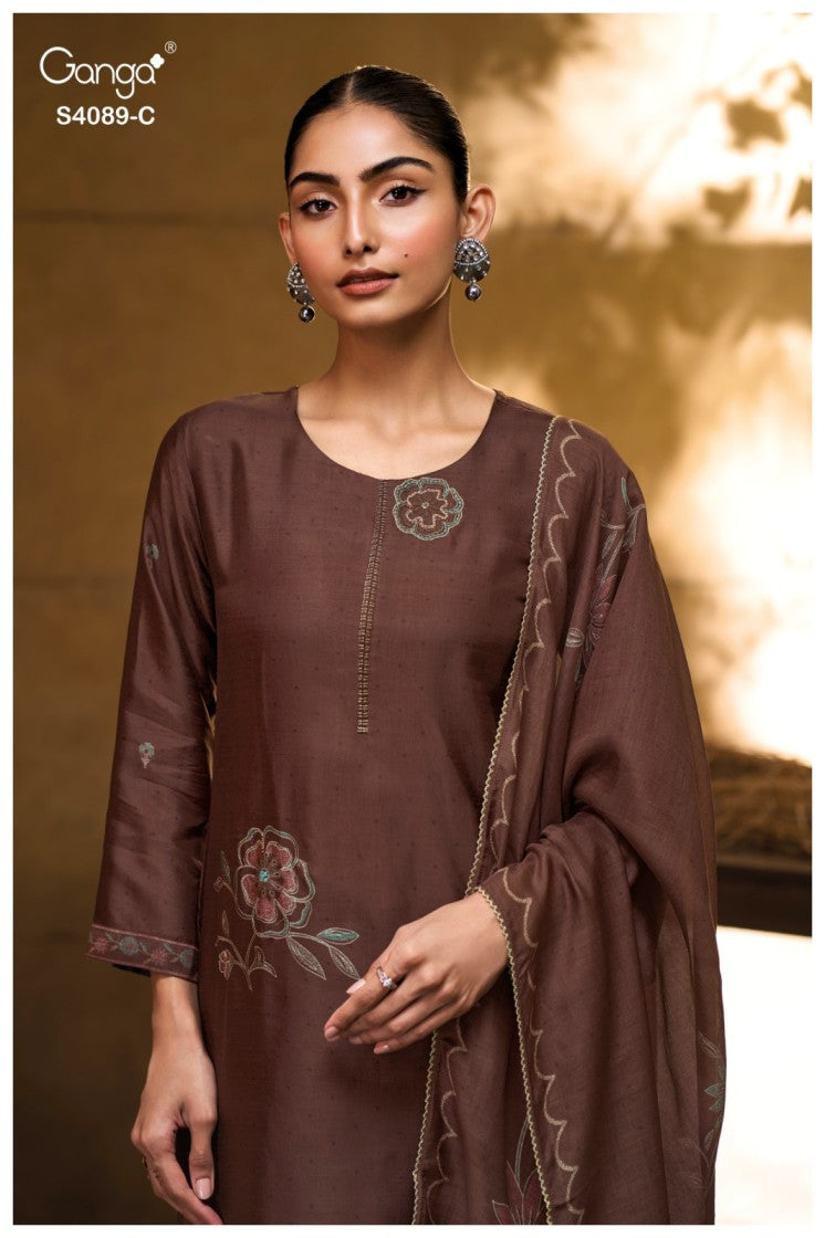 Woman wearing a brown embroidered outfit with a matching dupatta against a blurred background