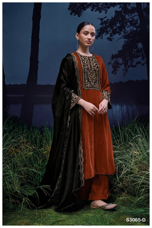 Woman in traditional outfit standing in a grassy area with trees in the background