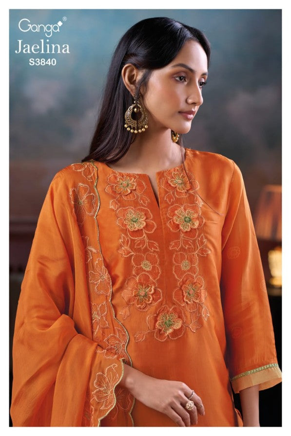 Woman wearing an orange embroidered outfit with 'Ganga' branding.