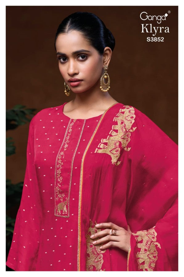 Woman wearing a pink embroidered outfit with 'Ganga Klyra' branding.
